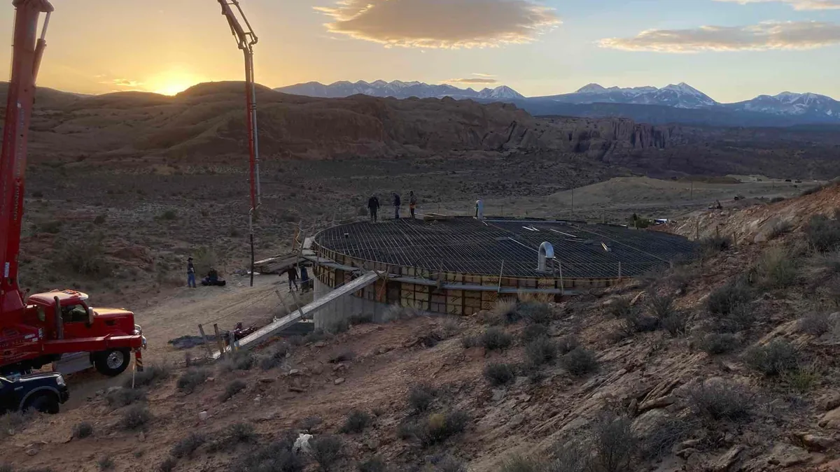 Crew placing the reinforced concrete roof of a culinary water tank at sunset